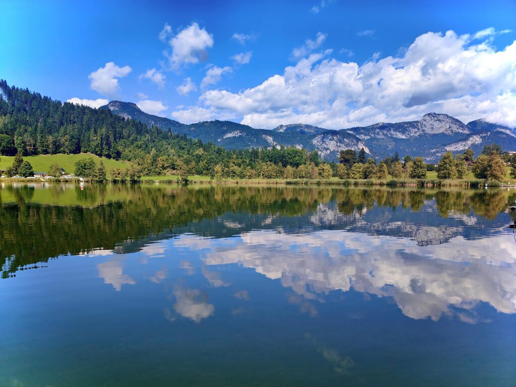 Stunning view of an alpine lake reflecting mountains and sky in Styria, Austria.