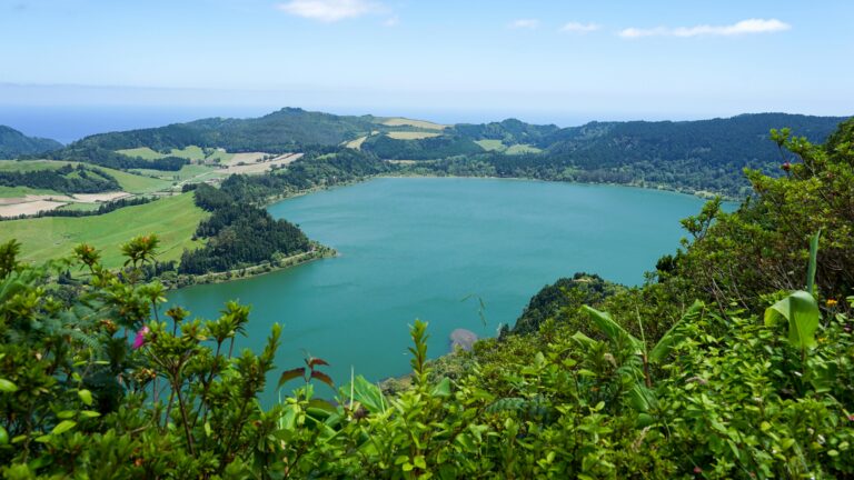 Breathtaking aerial view of a tranquil lake surrounded by lush green countryside and forests.